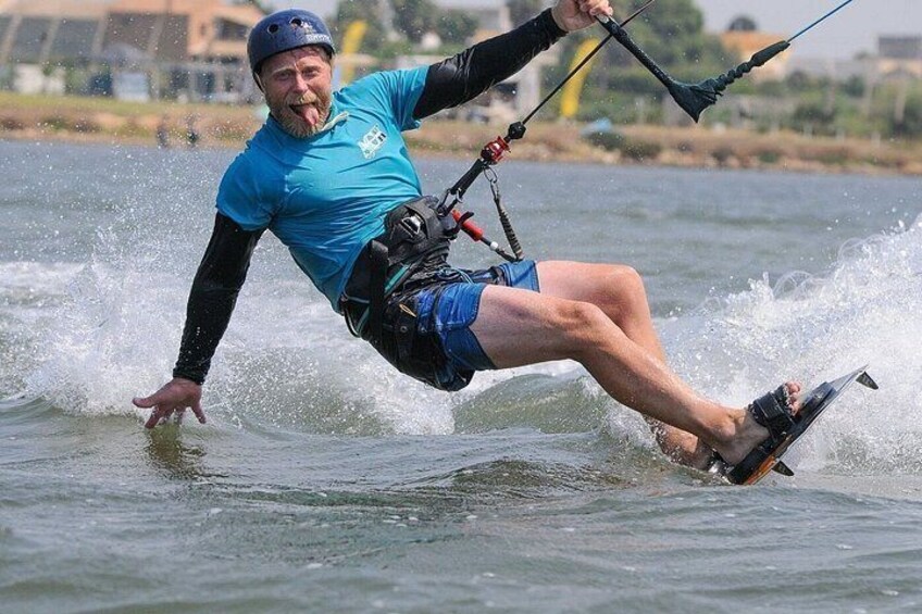 A person water skiing on a lake, wearing a helmet and a blue shirt. 2