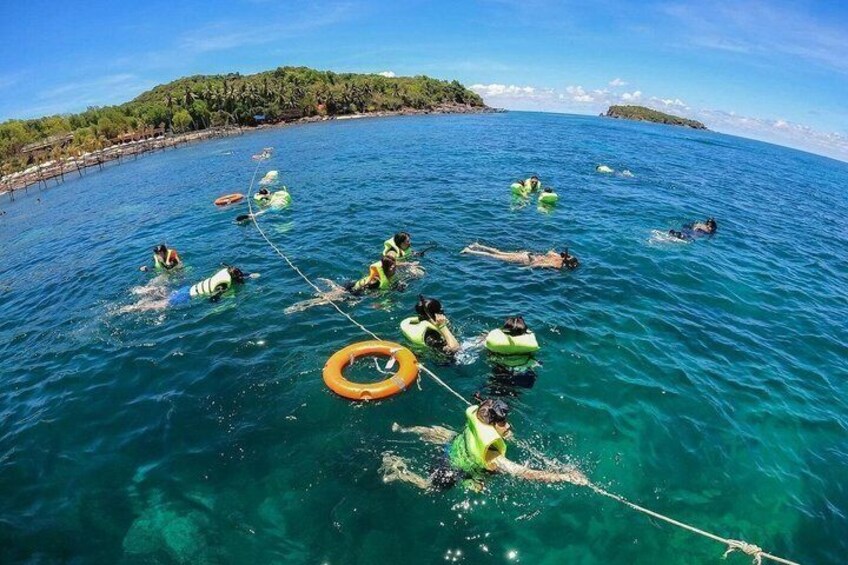 People swimming in a body of water with buoys and a rope. 2
