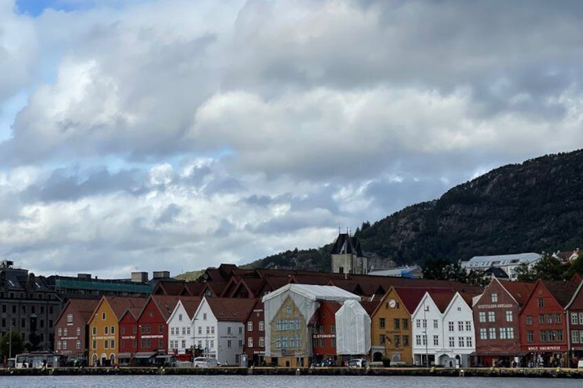 A row of colorful buildings with a church and a mountain in the background. 5