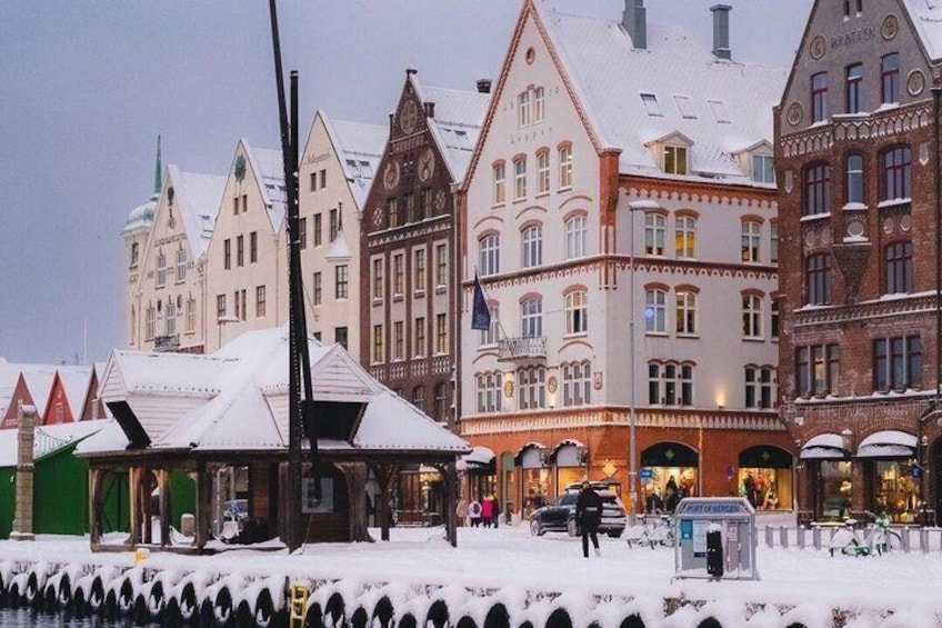 A snow-covered town square with historic buildings and a tram. 3