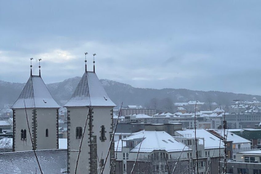 A snowy landscape with two prominent towers and a mountain range in the background. 4