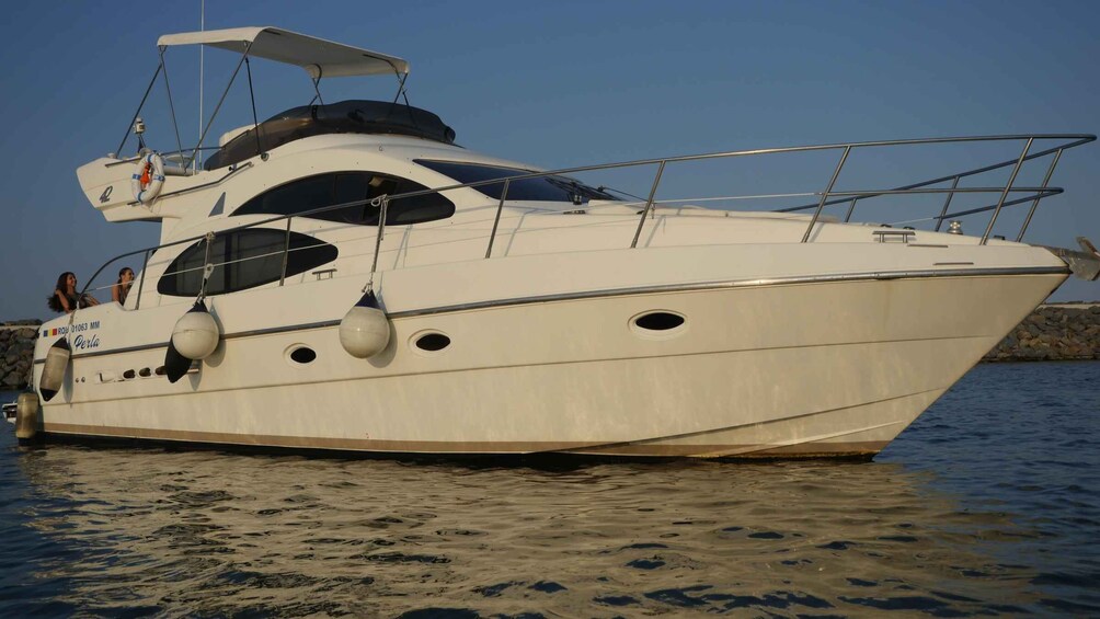 A white yacht named 'Perla' docked at a marina. 5