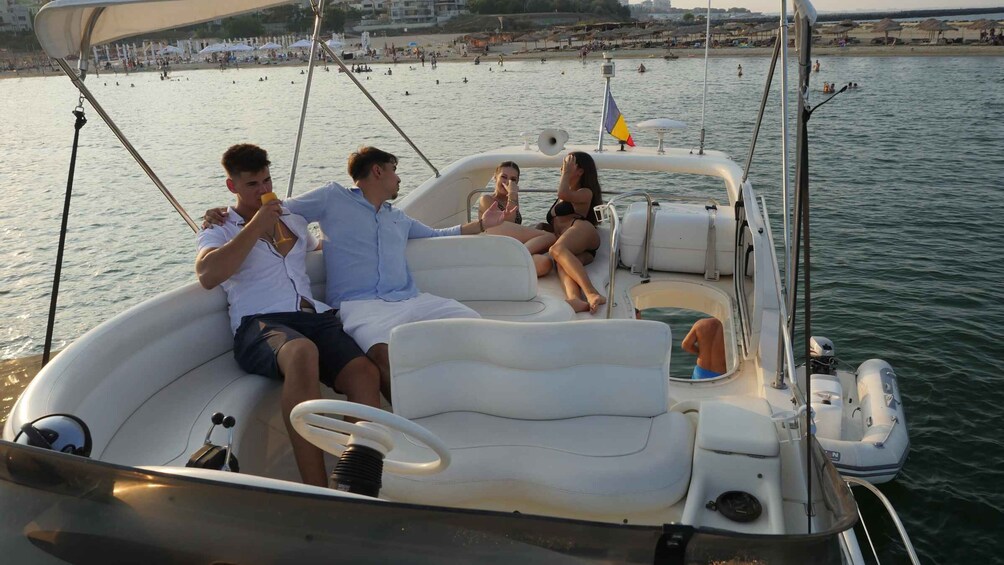 A boat with three people, a beach, and a cityscape in the background. 2