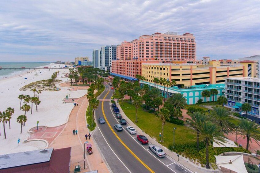 Eine Küstenstadt mit Strand, einer Straße und einem großen Hotel. 5