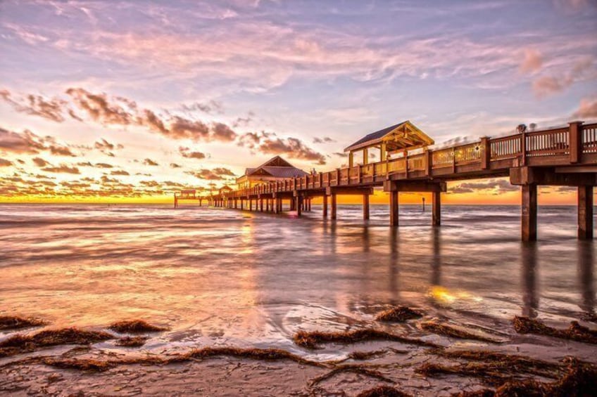 A wooden pier extending into calm waters at sunset. 5