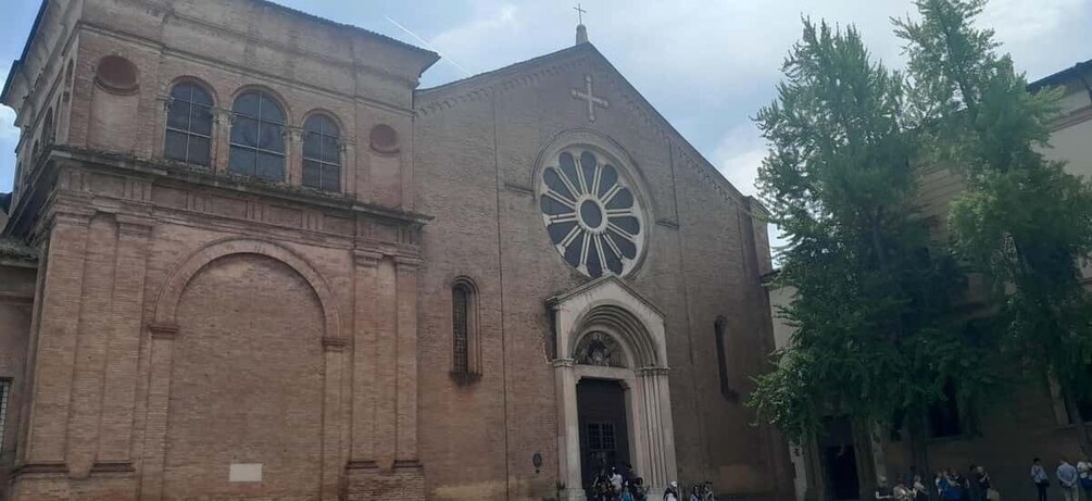 A historic church with a large circular window and a cross on the facade. 2