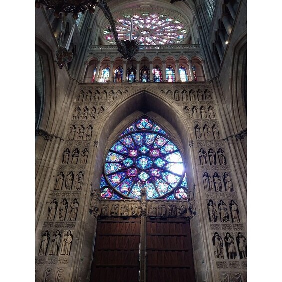 A Gothic-style cathedral interior with a large stained glass window and intricate stone carvings. 1