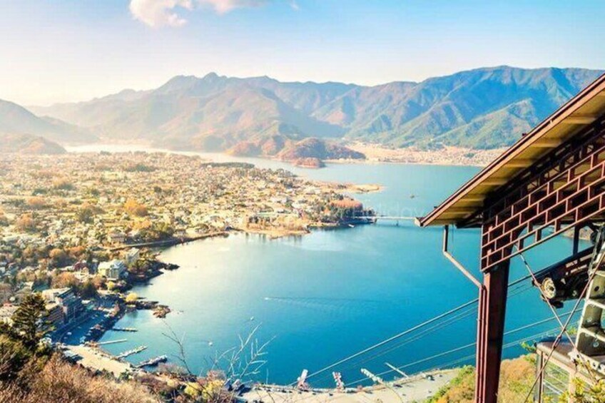 A panoramic view of a lake surrounded by mountains, a bridge, and a town. 3
