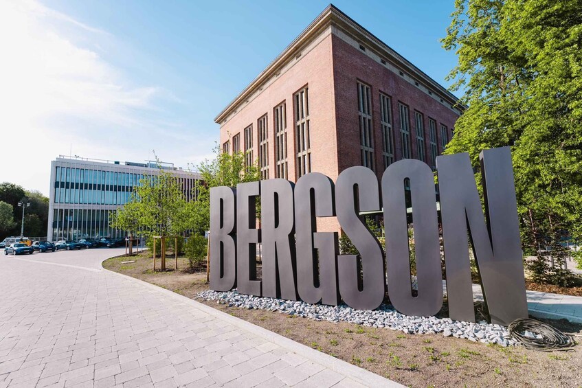 A building with a large sign reading 'BERGSON' and a parking lot with cars. 4