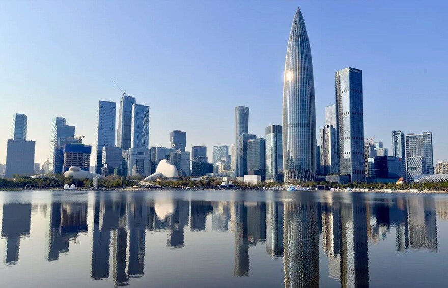 A city skyline with modern skyscrapers and a body of water reflecting the buildings. 1