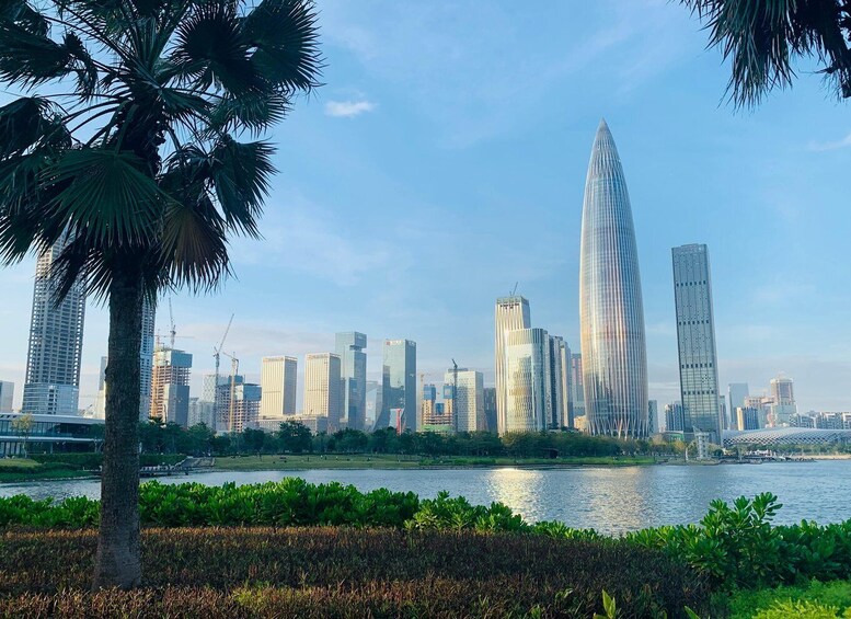 A city skyline with modern skyscrapers, a river, and a palm tree. 5
