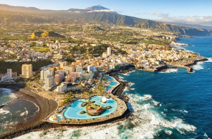 A coastal city with a prominent beach, a large resort area, and a mountain in the background. 5