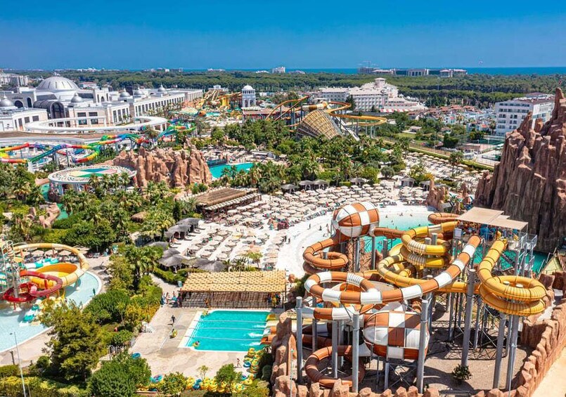 A water park with multiple slides and pools, surrounded by palm trees and buildings. 3