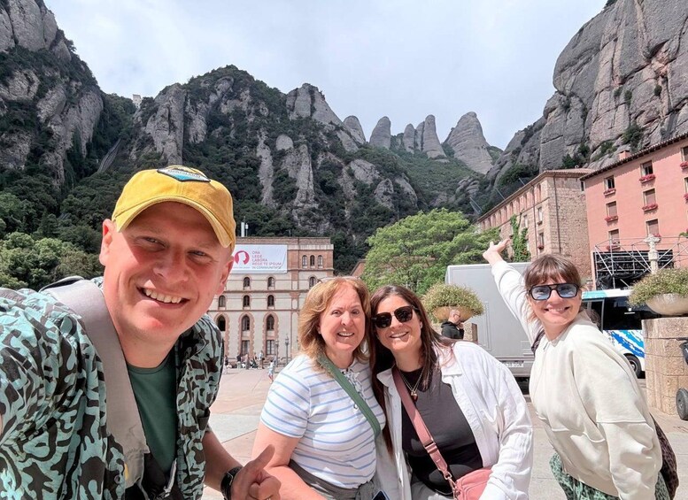 A group of people taking a selfie with a mountainous landscape in the background. 5