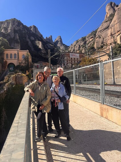 A group of people on a bridge with a mountainous landscape in the background. 3