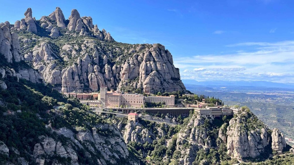 A monastery on a mountain with rocky cliffs and a clear sky. 2