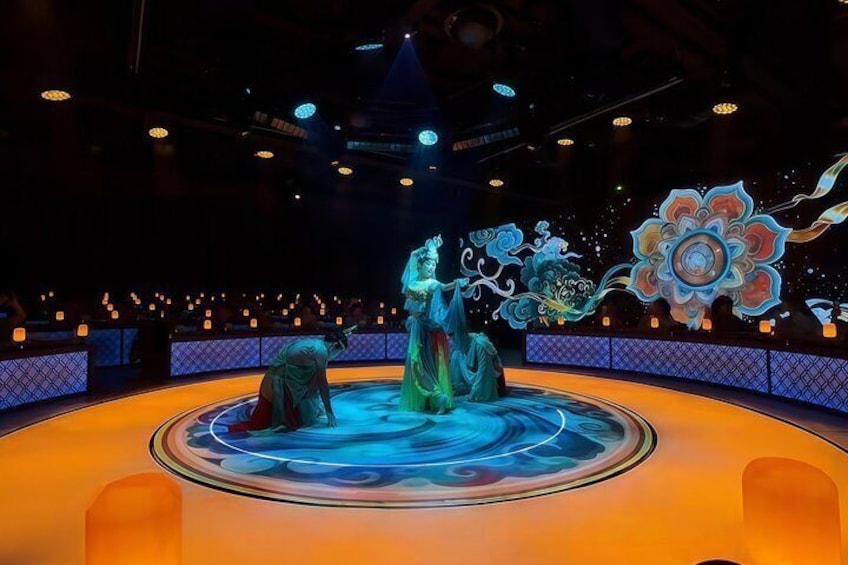 A stage with a circular platform, illuminated by spotlights, and a large floral design in the background. 5