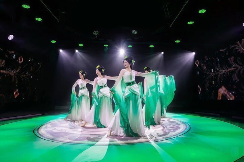 A stage with performers in green and white dresses. 1
