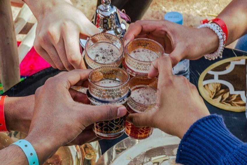A group of people holding glasses of a frothy beverage, likely beer, at a gathering. 5