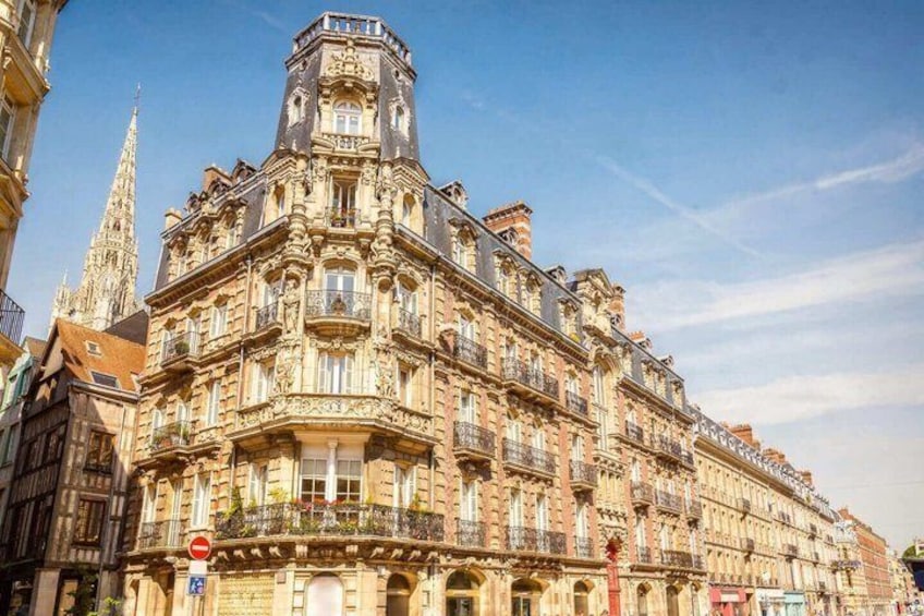 A historic building with ornate architecture, a prominent tower, and a clear blue sky. 2