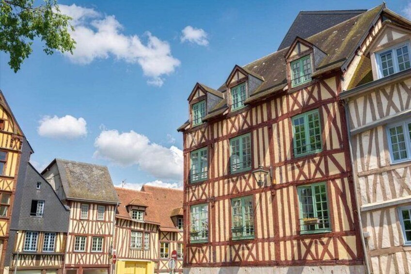 A row of half-timbered buildings with steep roofs and green shutters. 3