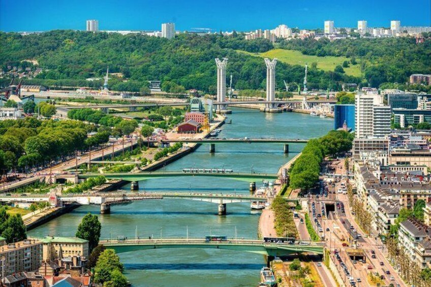 A river with bridges, a cityscape, and a hill with greenery. 4