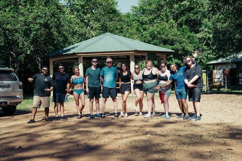 A group of people standing in a line outdoors with a gazebo in the background. 4