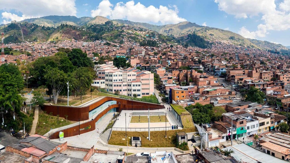A cityscape with a prominent modern building, dense residential areas, and surrounding hills. 2