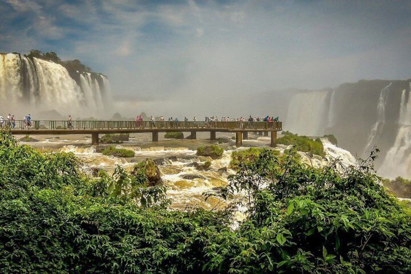 A waterfall, a bridge, and lush greenery. 3