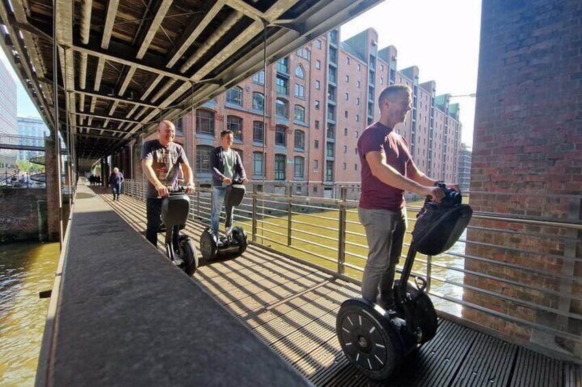 People riding Segways on a covered walkway over a canal. 2
