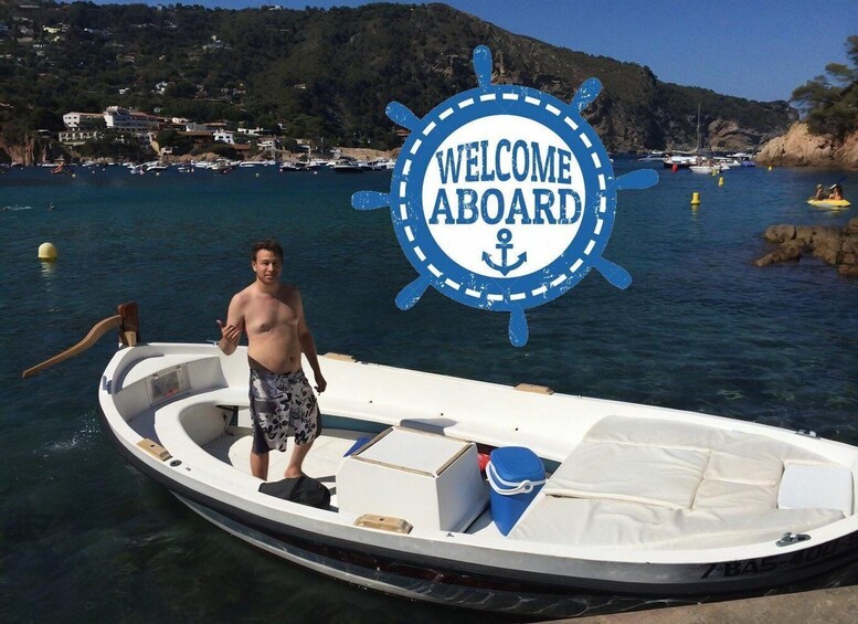 A small motorboat with a 'WELCOME ABOARD' sign, a person standing on the deck, and a coastal landscape with buildings in the background. 5