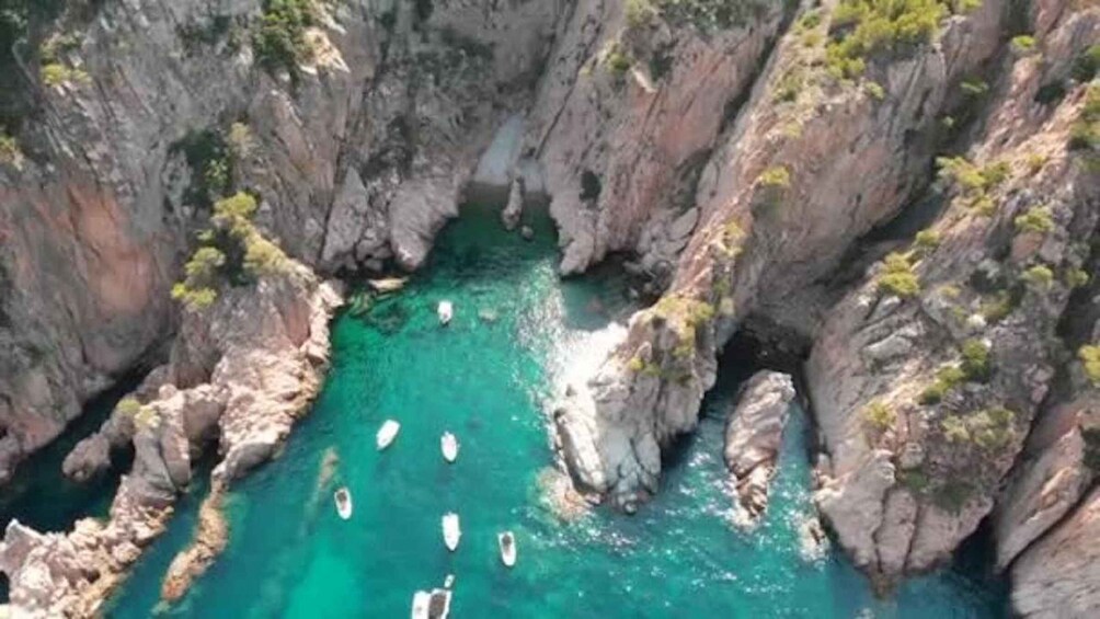 A canyon with turquoise water and boats. 3