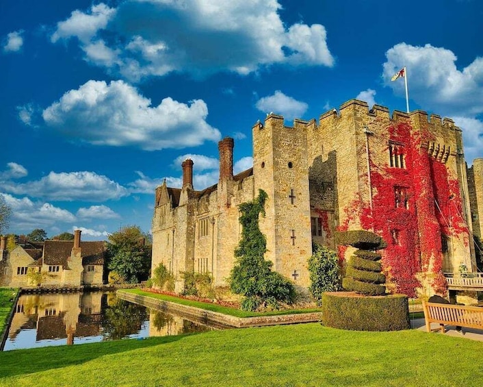 A historic castle with ivy-covered walls, a moat, and a clear blue sky. 1