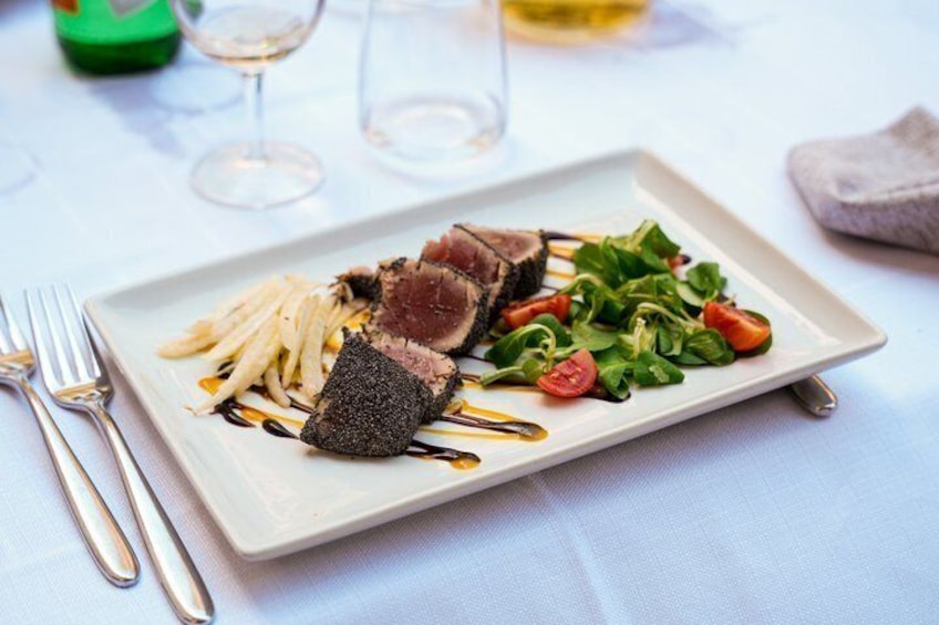 A plated meal with steak, fries, and a salad. 4