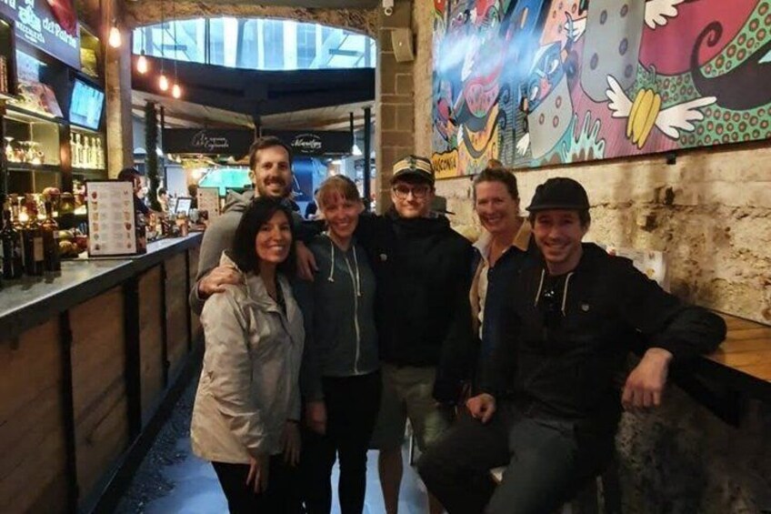 A group of people at a bar with a mural on the wall. 2
