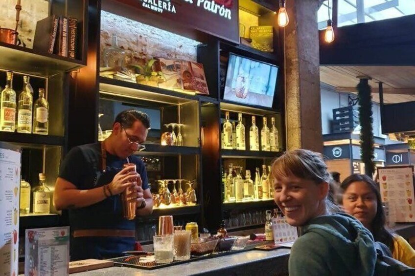A bar with shelves of liquor bottles and a television screen. 4
