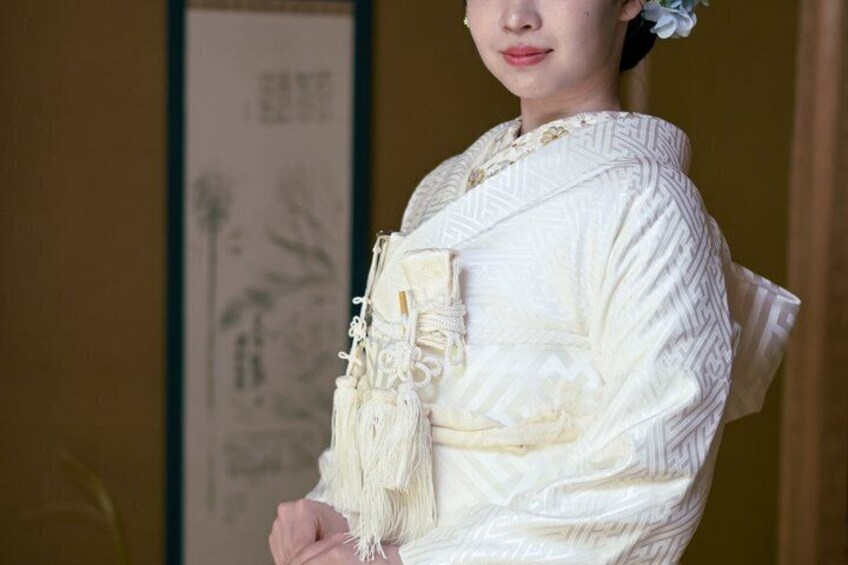 A person in traditional attire with intricate patterns and a white garment with lace details. 2