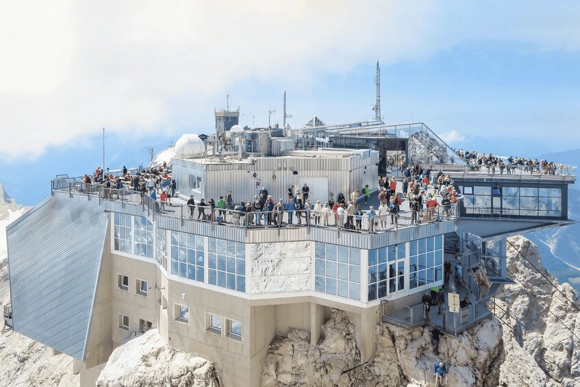 A mountain observation tower with multiple levels, surrounded by rocky terrain and overlooking a vast landscape. 4