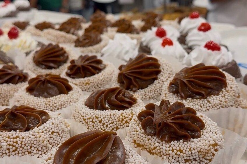 A variety of decorated pastries, including cupcakes with chocolate frosting and sprinkles. 3