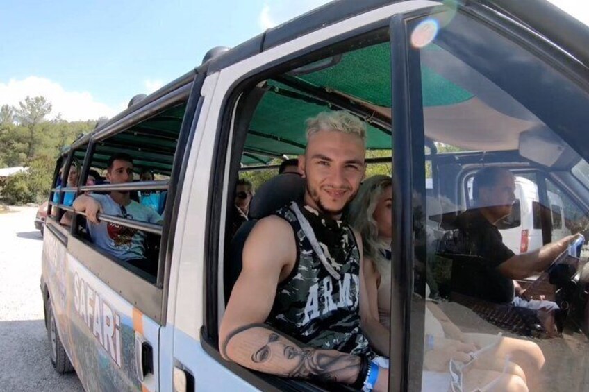 A vehicle with passengers, a person with tattoos, and a green canopy. 5