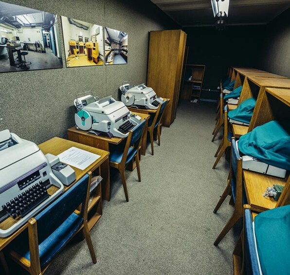 A classroom with desks, chairs, and vintage typewriters. 2