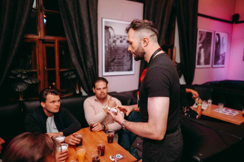A bar setting with people seated and one person standing, holding a drink. 5
