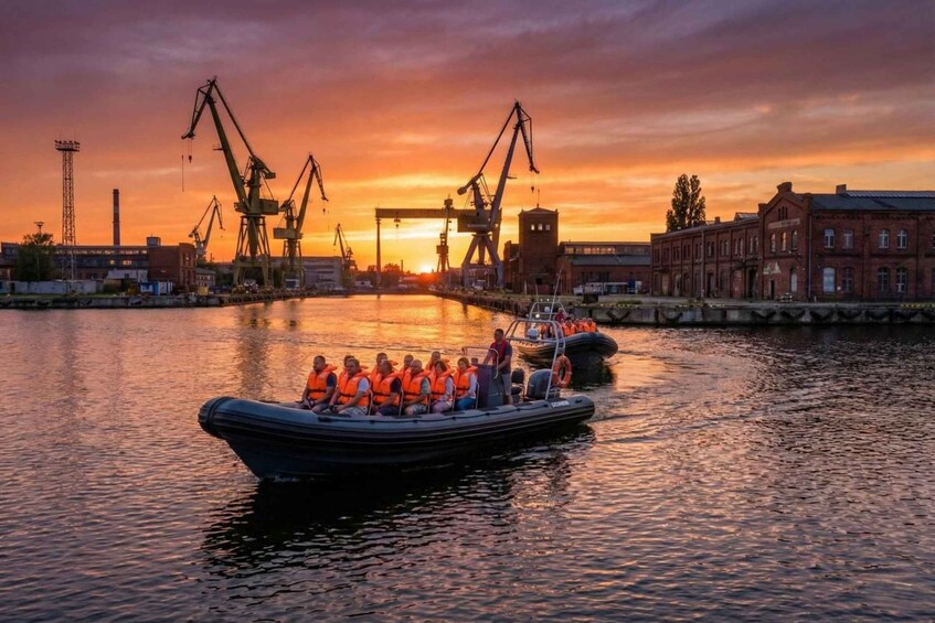 A sunset over a harbor with boats and industrial cranes. 3
