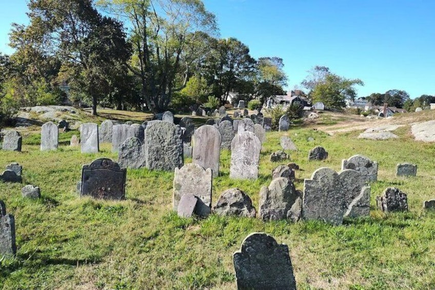 A cemetery with numerous headstones and a grassy landscape. 1