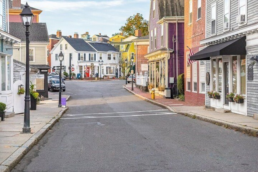 A quiet street lined with colorful buildings, a street lamp, and a fire hydrant. 3