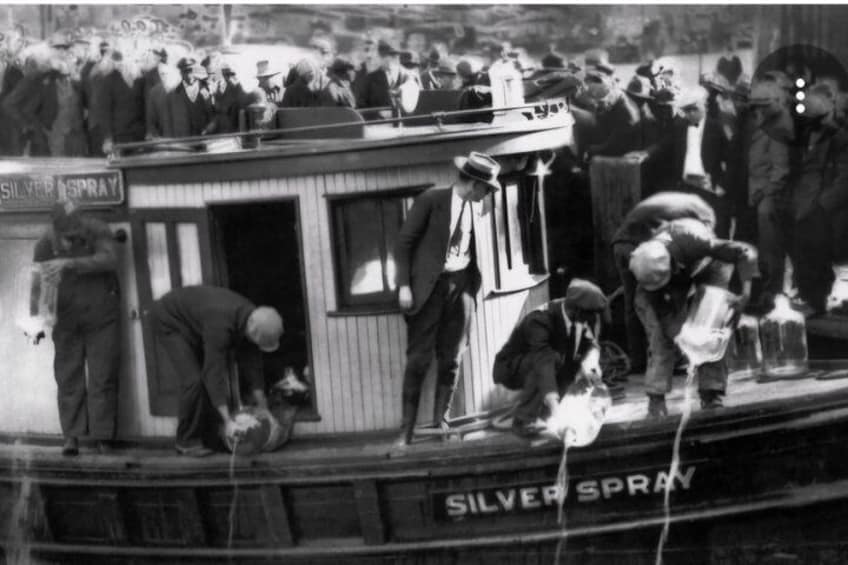 A boat with people handling silver spray containers, a crowd in the background, and a sign that reads 'SILVER SPRAY.' 5