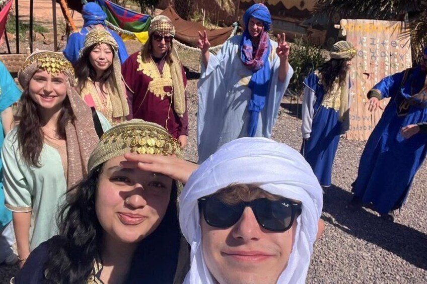 A group of people in traditional attire, some wearing headpieces and others in flowing garments. 2