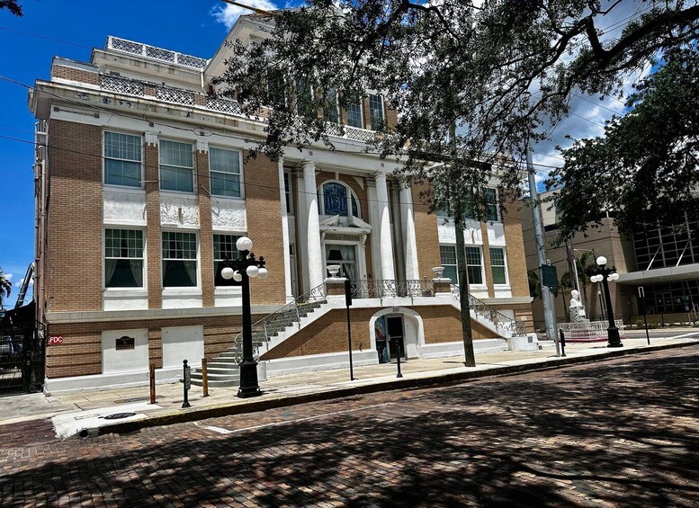 A historic building with a grand entrance, large windows, and a brick facade. 2