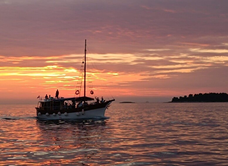 A boat with people on a calm sea at sunset. 1