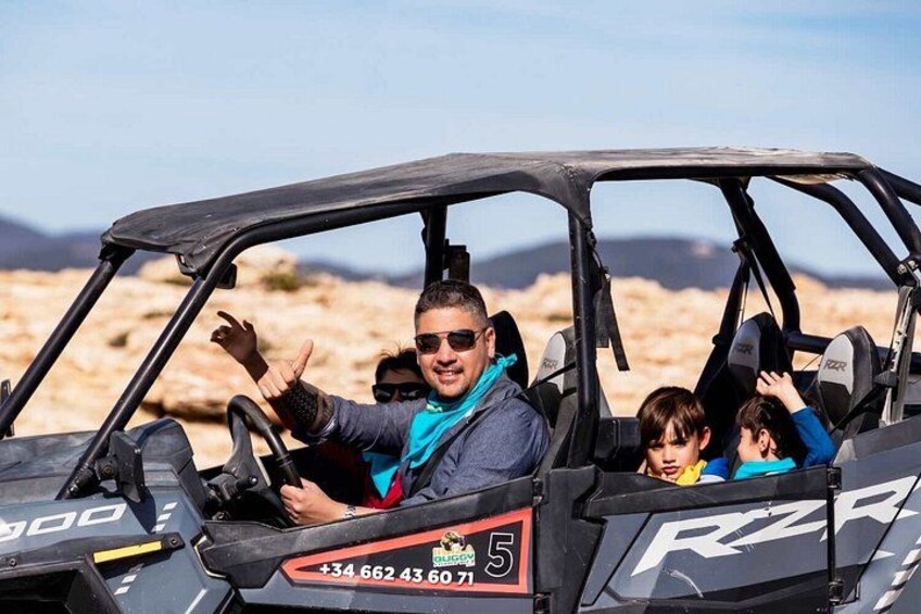 A desert landscape with a vehicle marked with 'RZR' and a phone number. 4